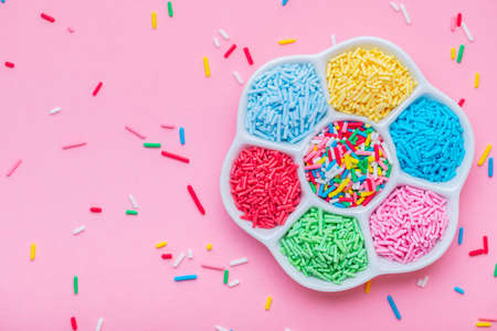 Colorful sprinkles in plate over pinkの写真素材
