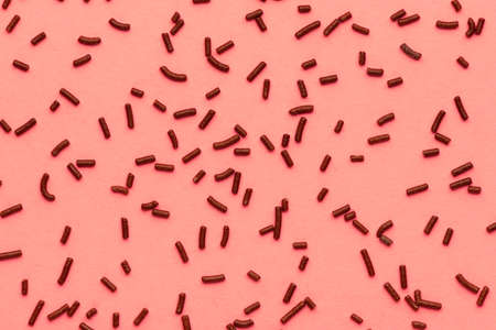 Pattern of chocolate sprinkles over trendy color living coralの写真素材