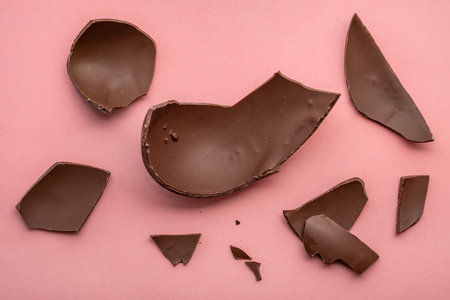 broken chocolate Easter egg over pink background, holiday conceptの写真素材