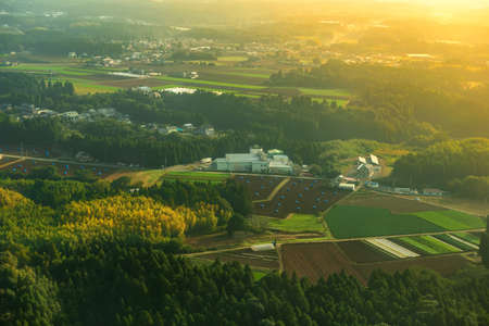 beautiful sunrise aerial view of rural landscape with green fields, houses and road in Asia, Japanの写真素材