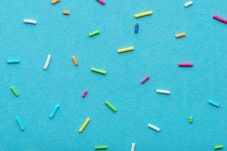flat lay of colorful sprinkles over blue background, festive decoration for Valentines day, birthday, holiday and party timeの写真素材