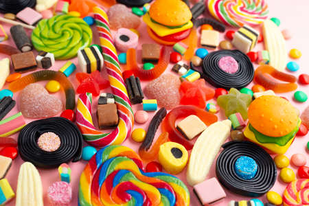 candies with jelly colorful array of different childs sweets and treats over pink like festive backgroundの写真素材