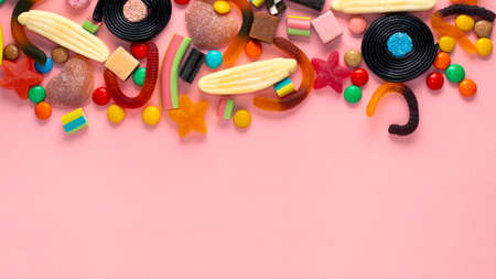 assortment of colourful lollipops and candies on pink like background,  copy space, panoramaの写真素材