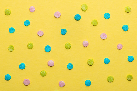 colorful round sprinkles over yellow background, decoration for festive Valentines day, birthday,...