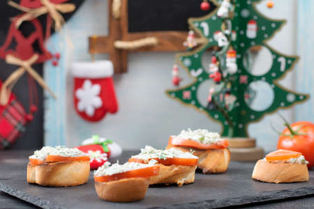 Toasts with cream cheese, herbs and tomatoes. Snack for New Year's table.の写真素材