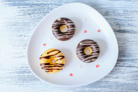 Three Donuts on plate decorated with heartsの写真素材
