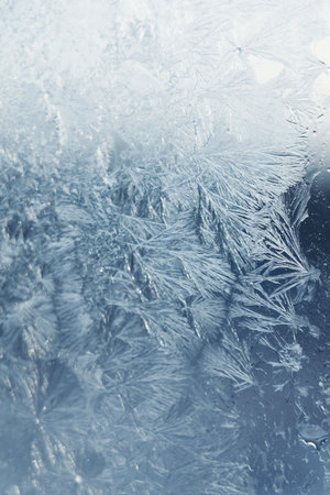 Wonderful hoarfrost pattern on glass in winter