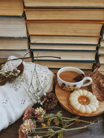 Autumn composition wirth coffee, scarf and books on table. Fall season leisure