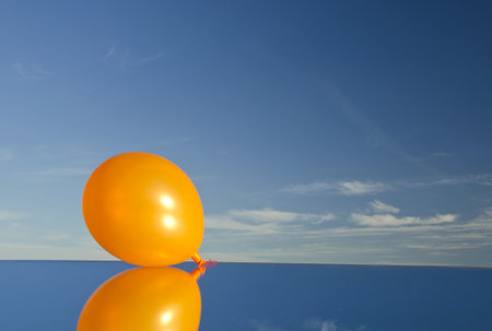 orange balloon on mirror and skyの写真素材