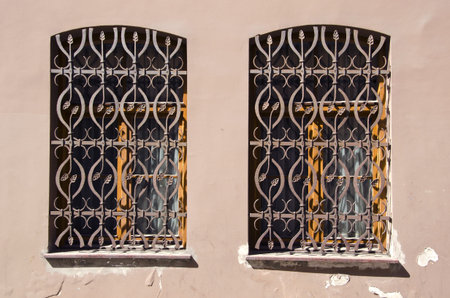 two old windows with ornamental metal gratings