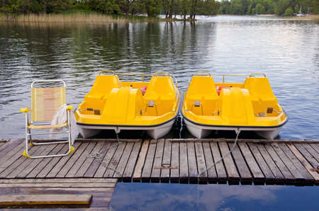 two yellow ppedalo on the resort spring lakeの写真素材