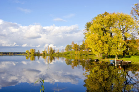 beautiful autumn lake evening landscape and boatsの写真素材