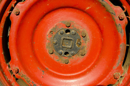 farm old tractor wheel detail red metal backgroundの写真素材