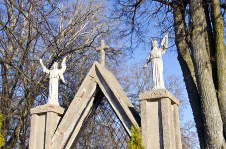two ancient angels statues on old gate in parkの写真素材