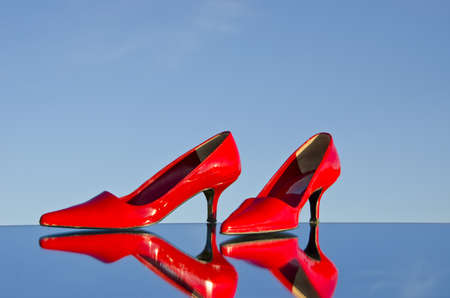 pair red beautiful stiletto on mirror and recflectionsの写真素材
