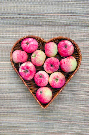 fresh summer apple in heart form basket. Healthy life conceptの写真素材