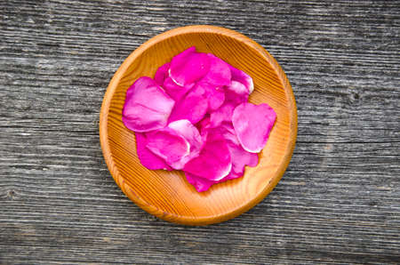 wild rose brier fresh petal for tea in wooden plateの写真素材