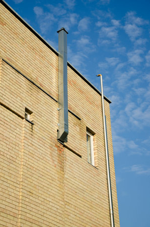 new industrial house wall with ventilation tube and sky