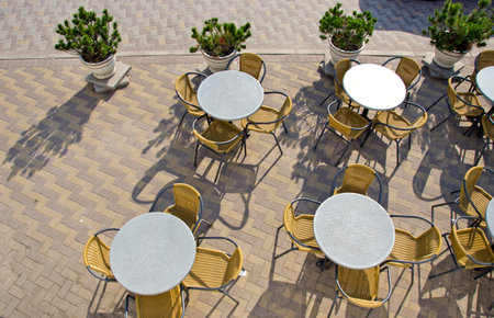 table and chairs in summer city street cafe on pavement