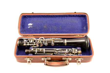 old used musical instrument clarinet in ancient case isolated on white