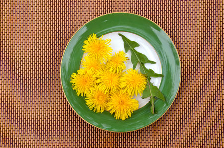 fresh spring dandelion leaf and flowers in plate. Healthy natural vegetarian foodの写真素材