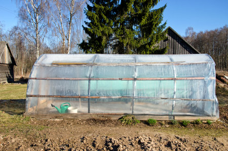 plastic handmade polythene greenhouse in spring farm gardenの写真素材