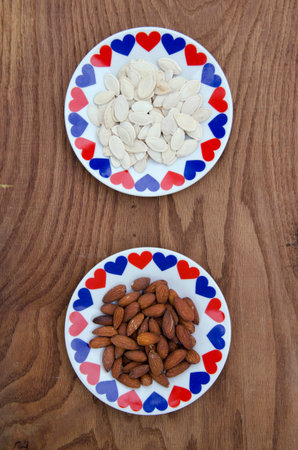 almond and pumpkin seed in ceramic plate with hearts. Healthy food