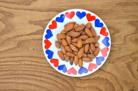 almond kernel in ceramic plate with hearts on tableの写真素材