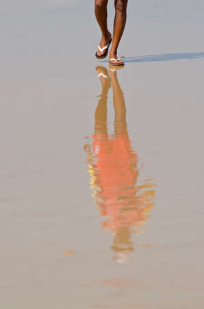 tourist shadow on wet sea beach sand in Goa resort, Indiaの写真素材