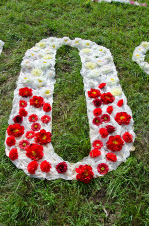 beautiful cloth and flower alphabet letter O on grass in parkの写真素材