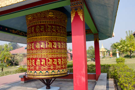 big ornate buddhists prayer wheel in Lumbini temple garden, Nepalの写真素材
