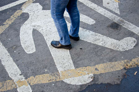 signs on urban asphalt street background and people feetの写真素材