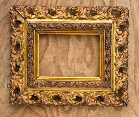 ancient wooden ornate art picture frame on wooden backgroundの写真素材