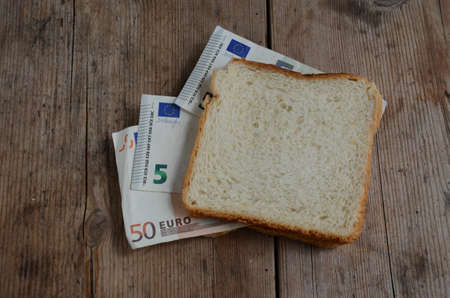 slice white bread with euro money banknotes on tableの写真素材