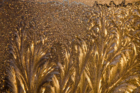 beautiful ice pattern background and sunlight on winter window glassの写真素材