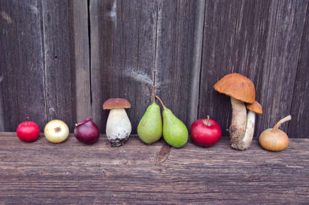 various fresh mushrooms, fruits and vegetables on old wooden backgroundの写真素材