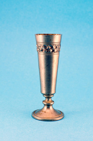 vintage ornamental metal silver wine goblet cup on blue background