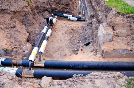 plastic modern technology black heating pipes in trench near city house