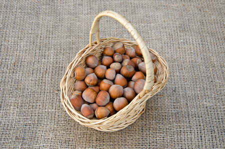 Hazel nuts in wicket basket on linen - healthy foodの写真素材
