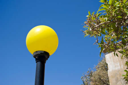 Vividly yellow lampost in the daylightの写真素材