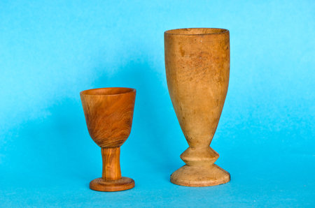 Two wooden antique handmade glasses cup on blue backgroundの写真素材