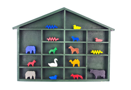 Green painted wooden shelf with a roof filled with various wooden animal toy figurines isolated on whiteの写真素材