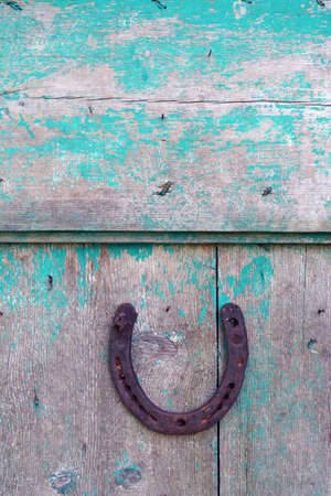 Rusty horseshoe on painted peeling blue wooden backgroundの写真素材