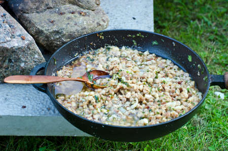 Cooking cooking porridge in frying pans on fire in town medieval festivalの写真素材