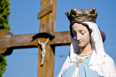 vintage sculpture of St. Mary fragment and blur cross