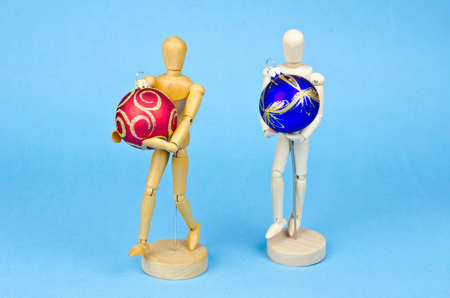 Two wooden artist manikin with christmas baubles on blue azure backgroundの写真素材