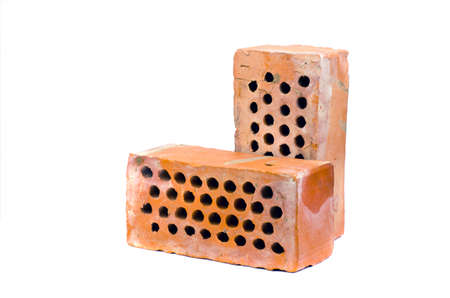 Two old red clay brick with holes isolated on white backgroundの写真素材