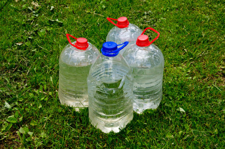 four plastic water bottle on garden grass
