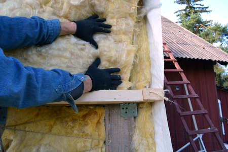 worker hands on house wall insulatiom material rockwoolの写真素材