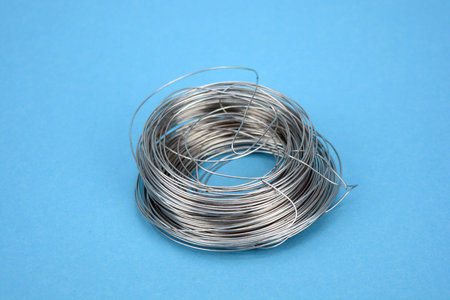 New steell metal  wire roll on blue background